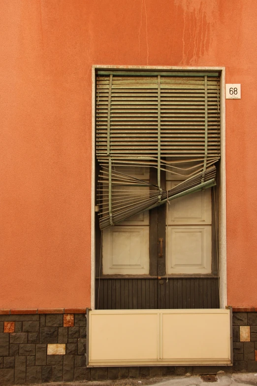 the closed shutters and door of an apartment building