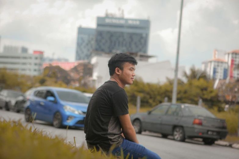 a man sits on the curb waiting for his next ride