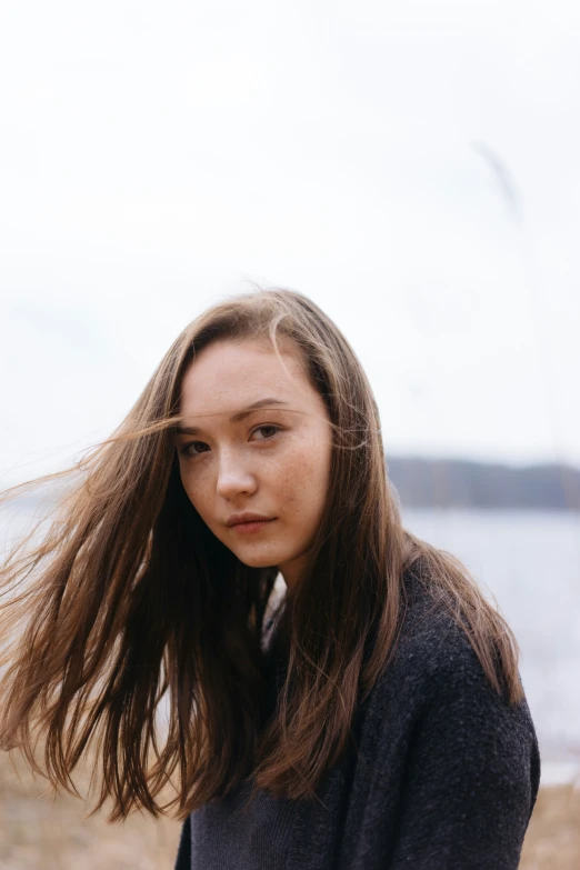 woman with long hair near water on beach