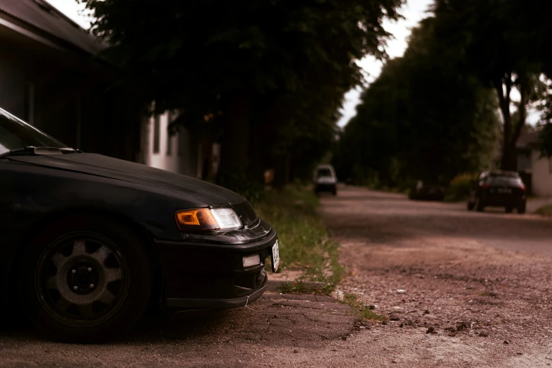 a black car parked by a curb on the side of the street