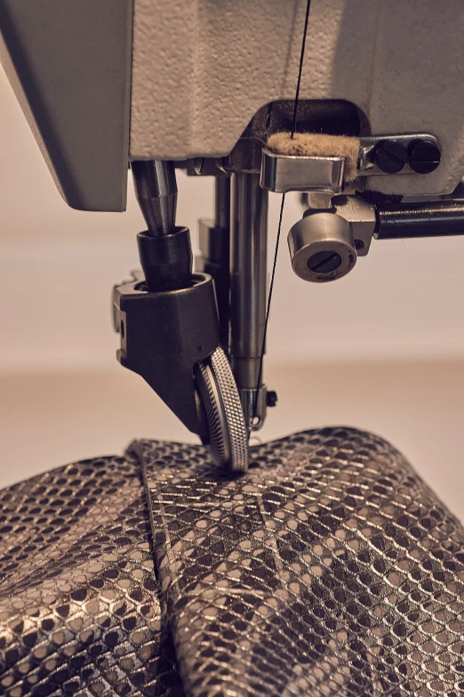 a small sewing machine that is working on some fabric