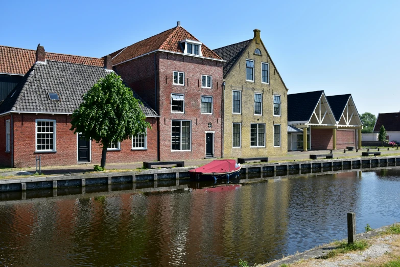 three houses are reflected in the water of the river