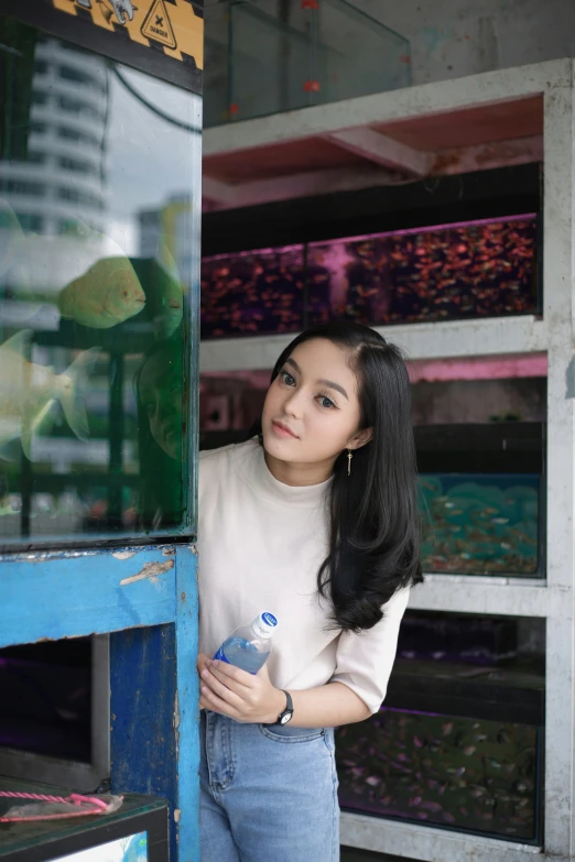 a woman in white top leaning on the wall