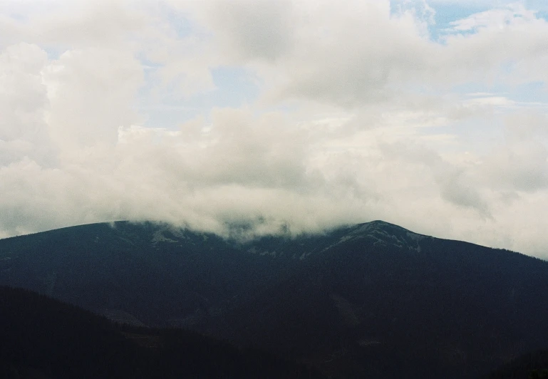 there are very big clouds behind the mountains