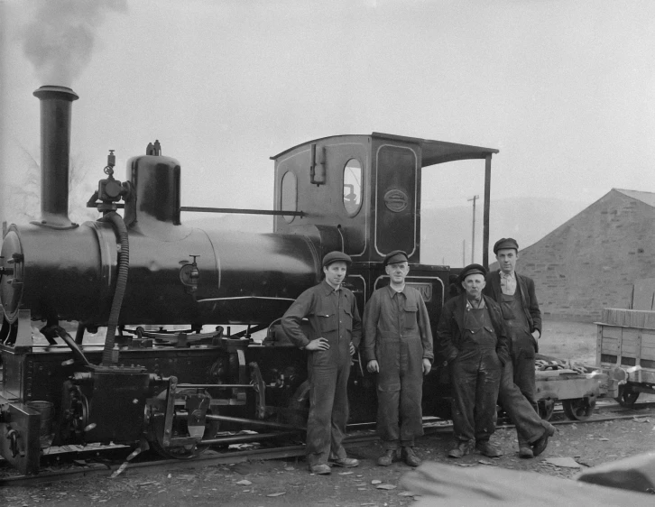 the four men are posing next to an old steam engine