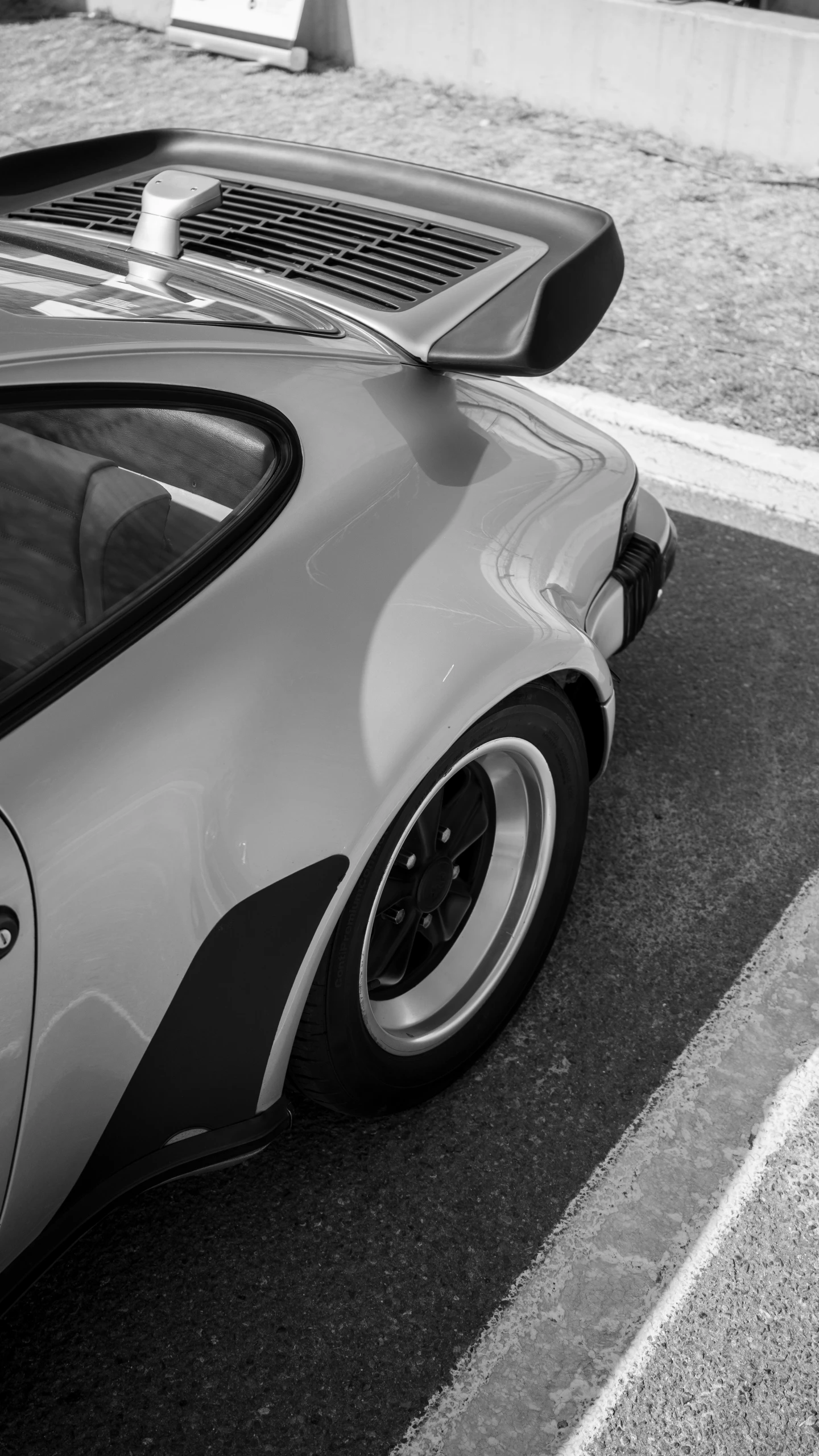 black and white image of a car parked on the side of the street