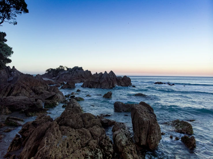 several rocks on the water in front of some water