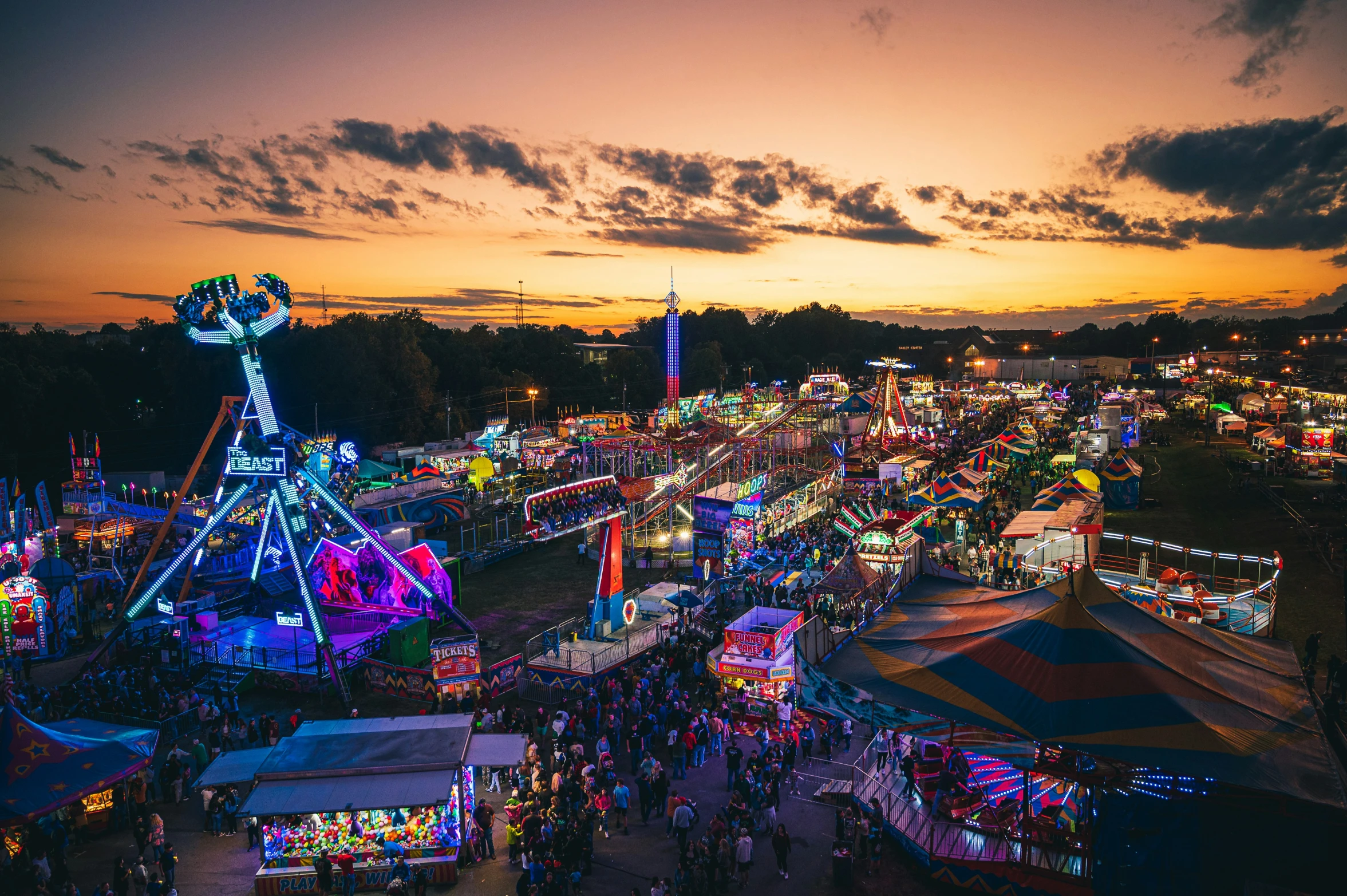 a carnival with lots of rides and rides at dusk