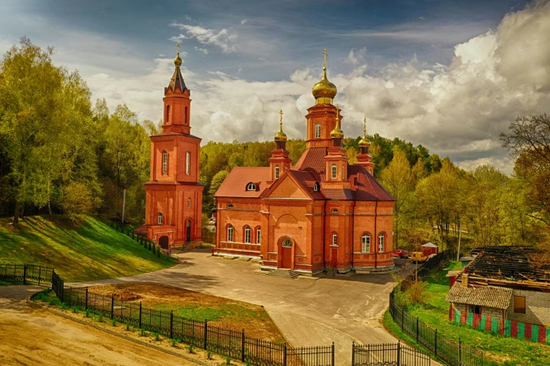 an old church with a tower on top sits in the middle of a grassy area