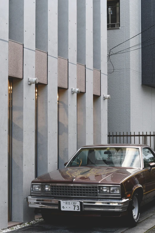 an old brown car is parked outside a building