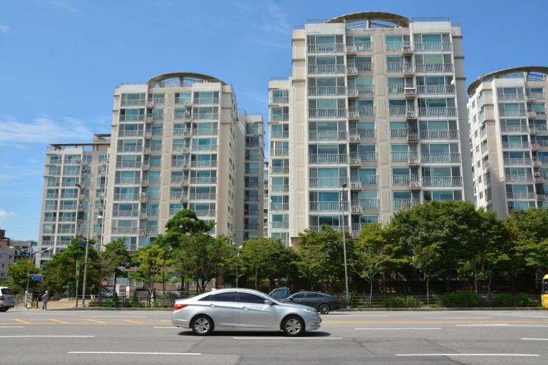 a very tall apartment building across the street from a parking lot