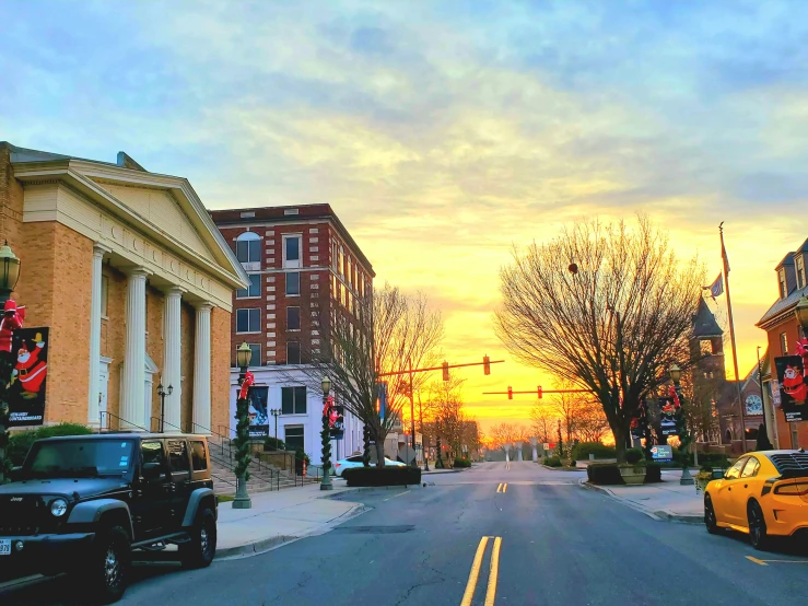 the sun is setting in a small city