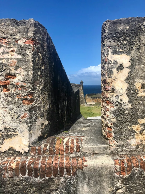 an alley between two ancient walls at the ocean