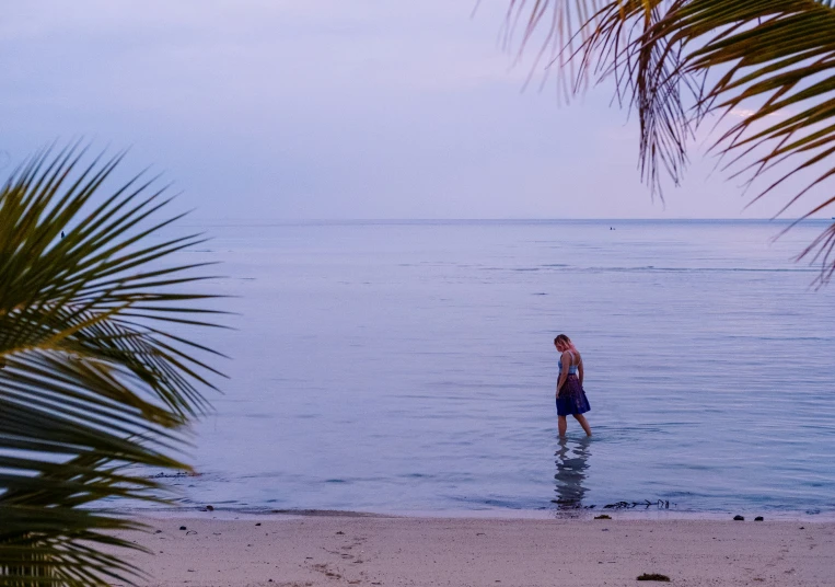 a man standing in the ocean with his surf board