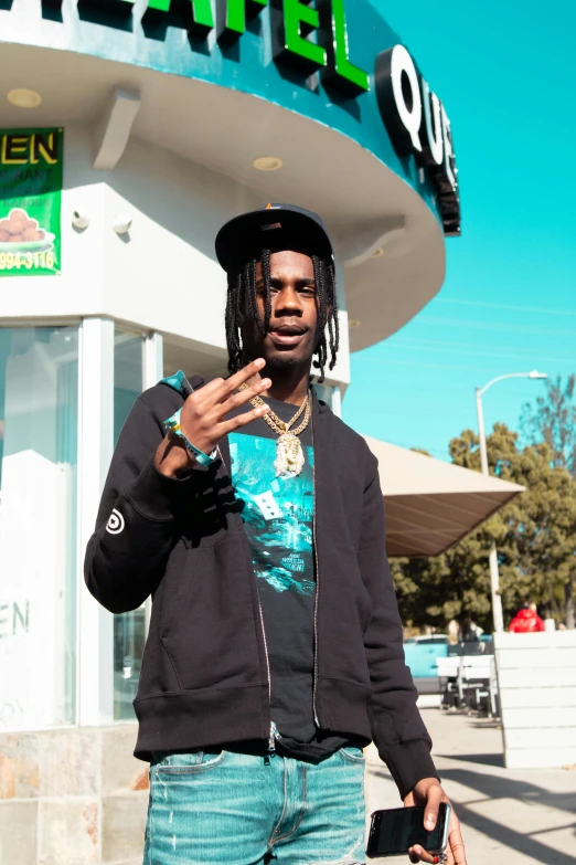 a man with dread locks, a hat and jeans is posing in front of a store