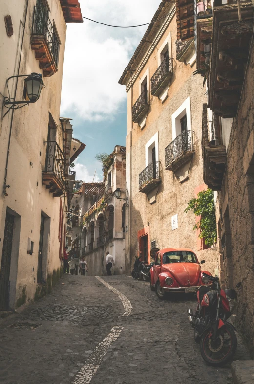 small cars parked on the side of old narrow street