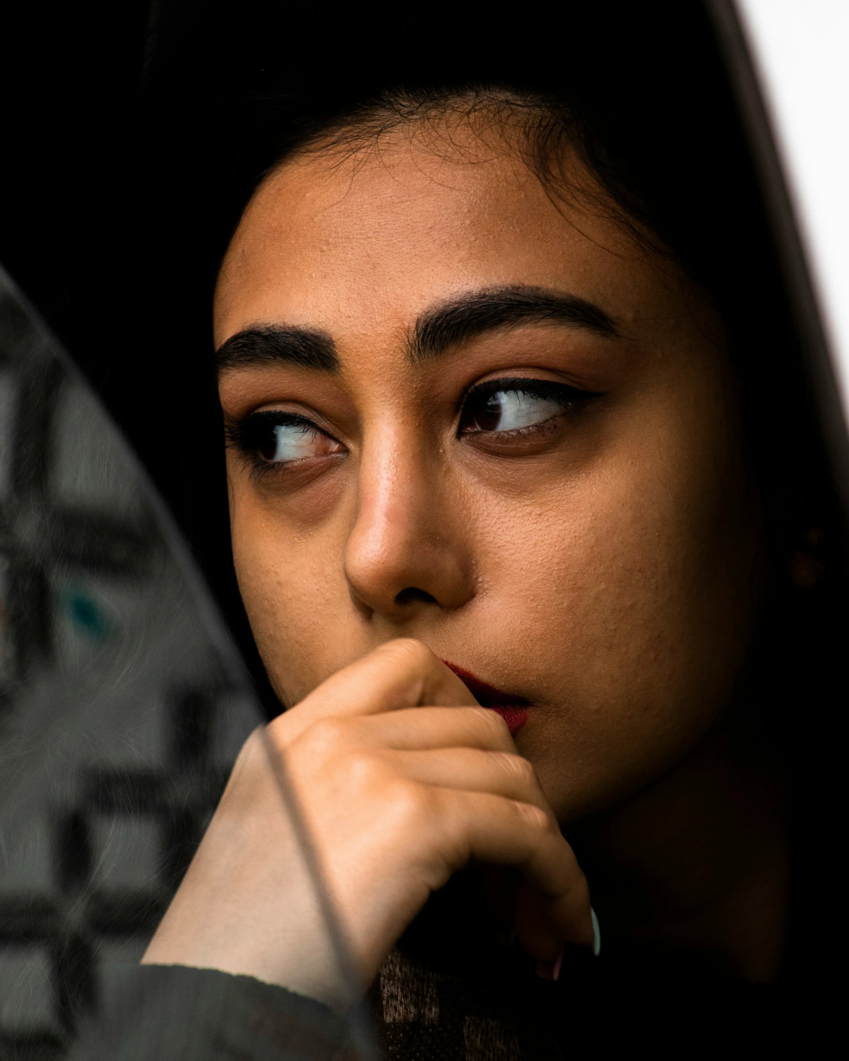 a young woman looking out the window with one eye wide open