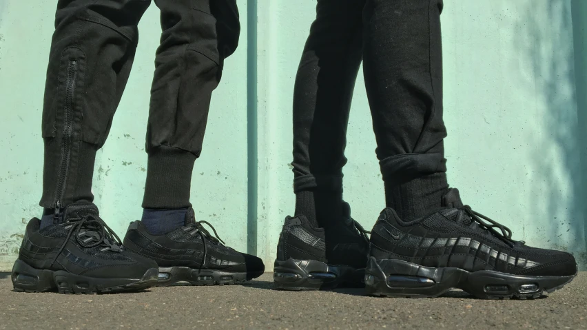 a pair of people standing on top of a dirt road