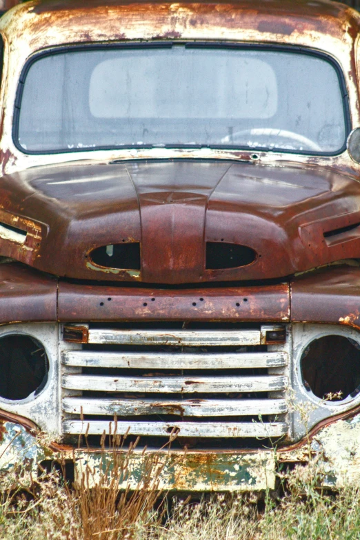 an old rusty truck that has it's headlights missing