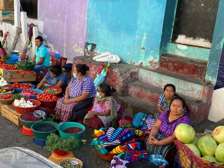 women sitting in the street selling fresh fruit