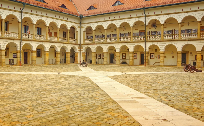 courtyard of building with cobblestones and horses,