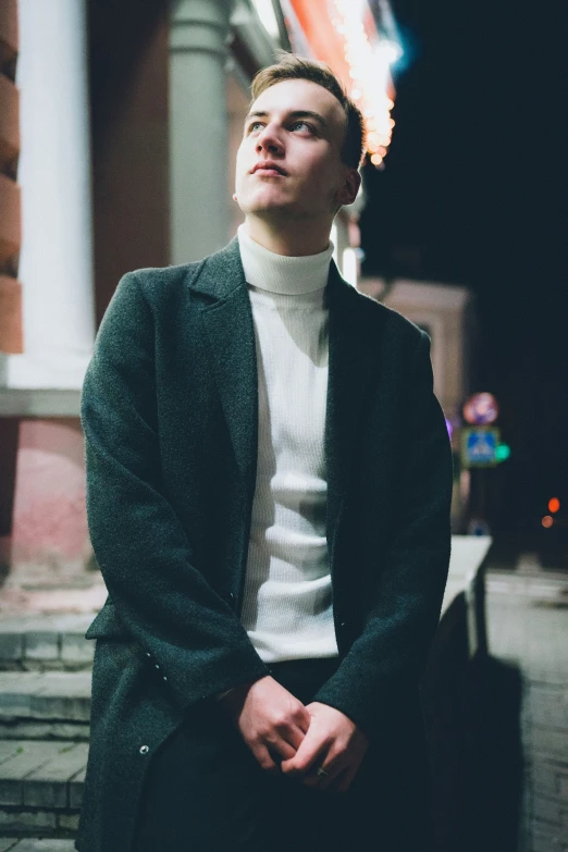 a man sitting on a sidewalk next to a building