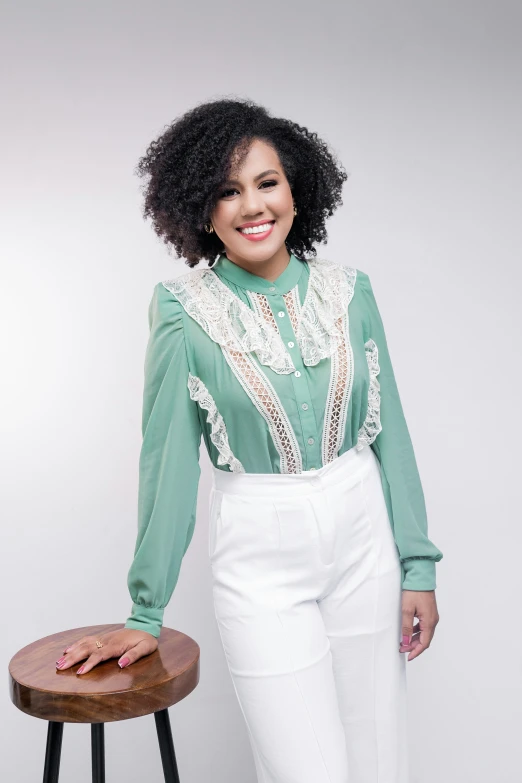 an african woman standing next to a stool