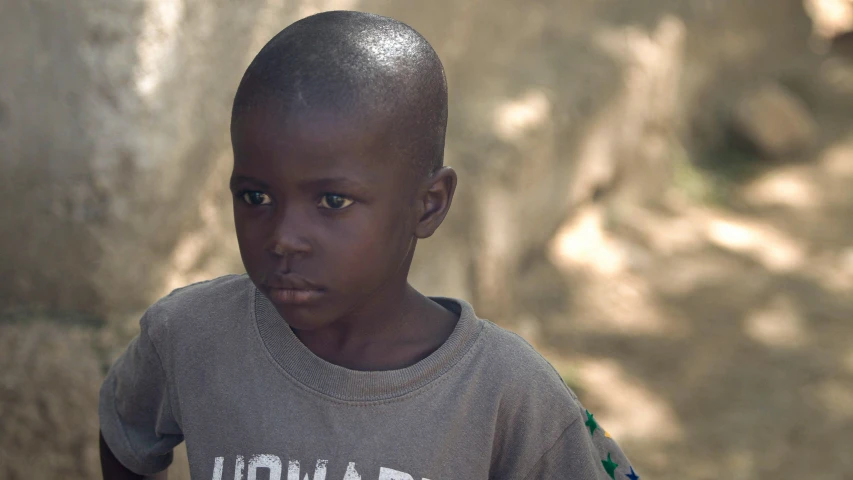 a young black child in front of a wall