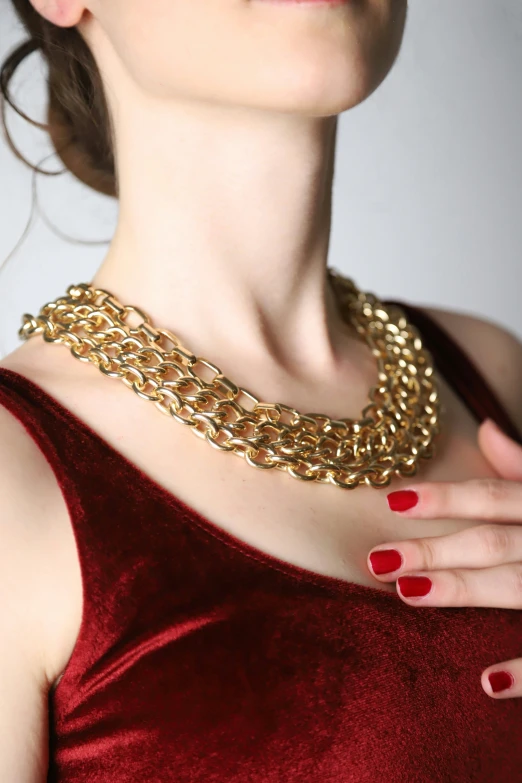 a young woman with red nails and a gold chain choker