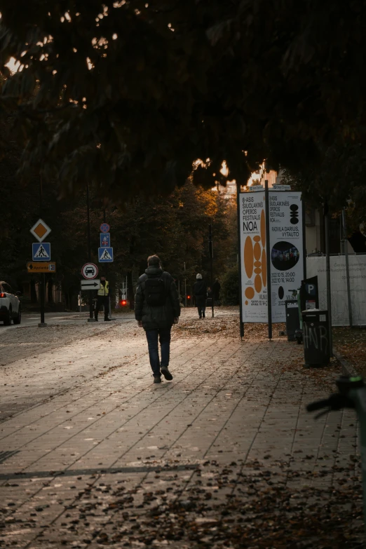 man walking on brick street during evening in city