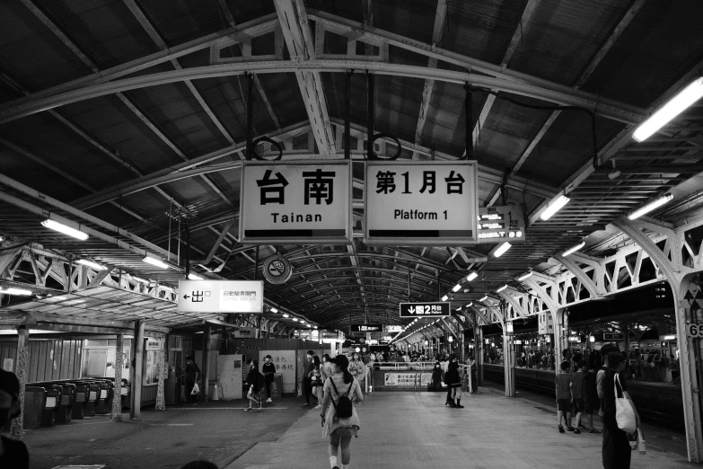 the interior of a train station, with pedestrians walking around