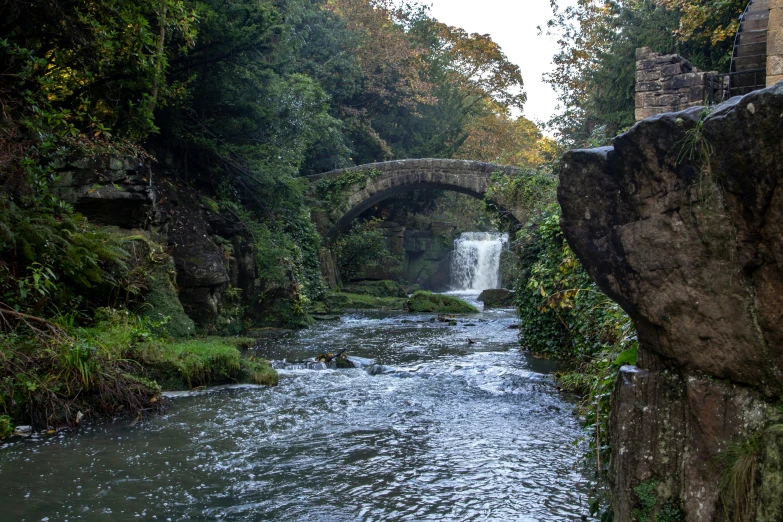 the stone bridge over the river has a stone arch over it