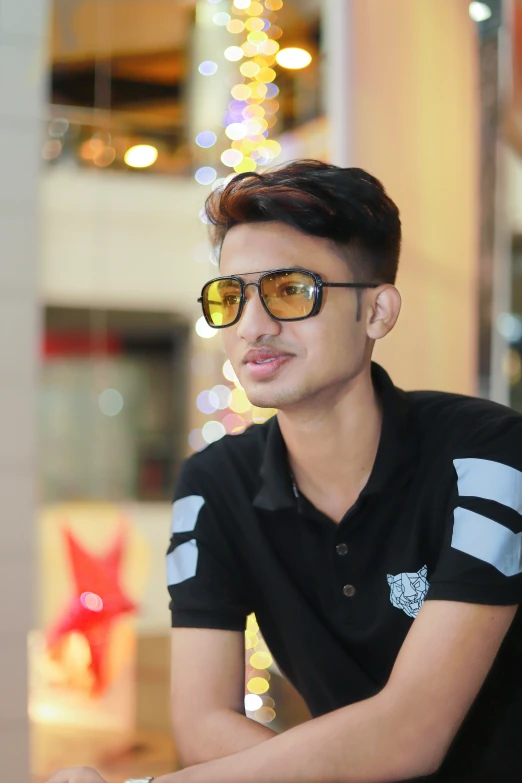 young man in sunglasses sits at the counter