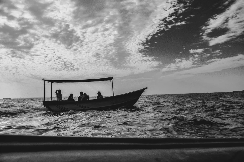 people on small boat at sea while it has cloudy skies