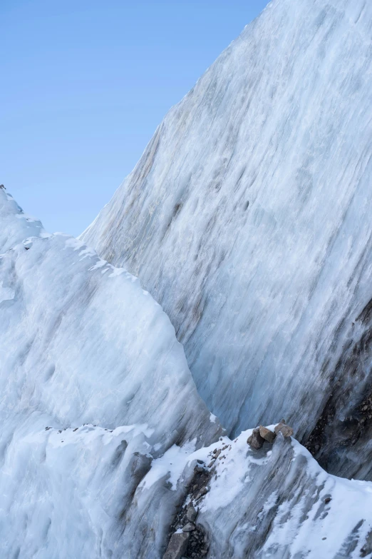 two skiers climbing the side of a very steep mountain