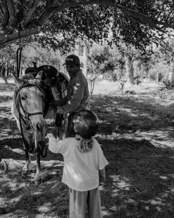 a black and white po of a person feeding a horse