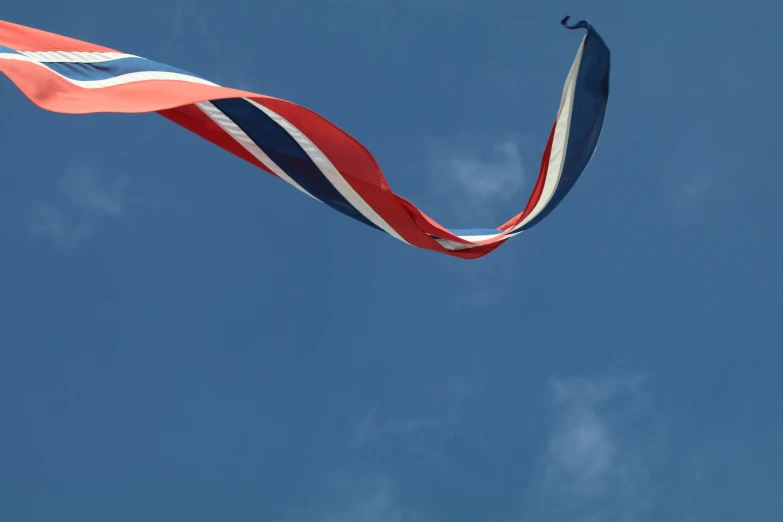 a large red, white and blue flag on top of a kite