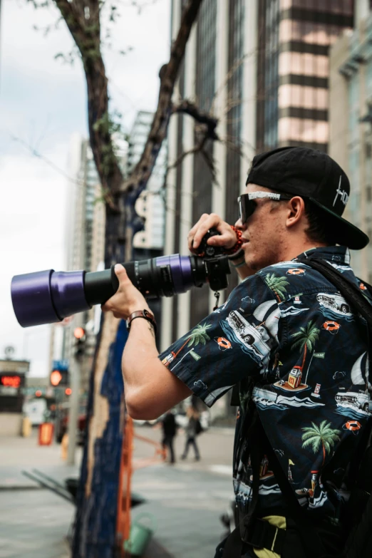 a man wearing sunglasses and a printed shirt takes his picture on the street