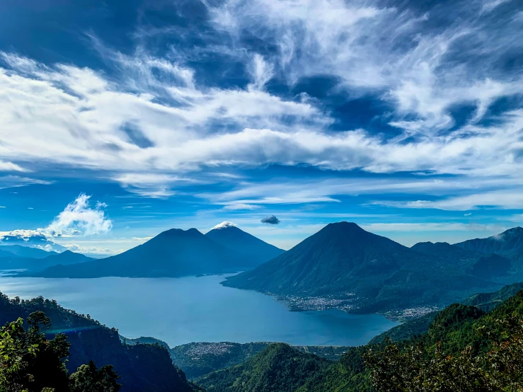 a group of mountains and water with some clouds