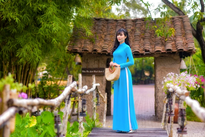 a young woman poses for a po in a blue dress