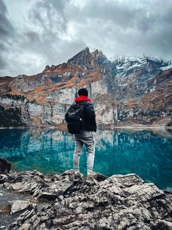 a man standing on rocks in front of some water