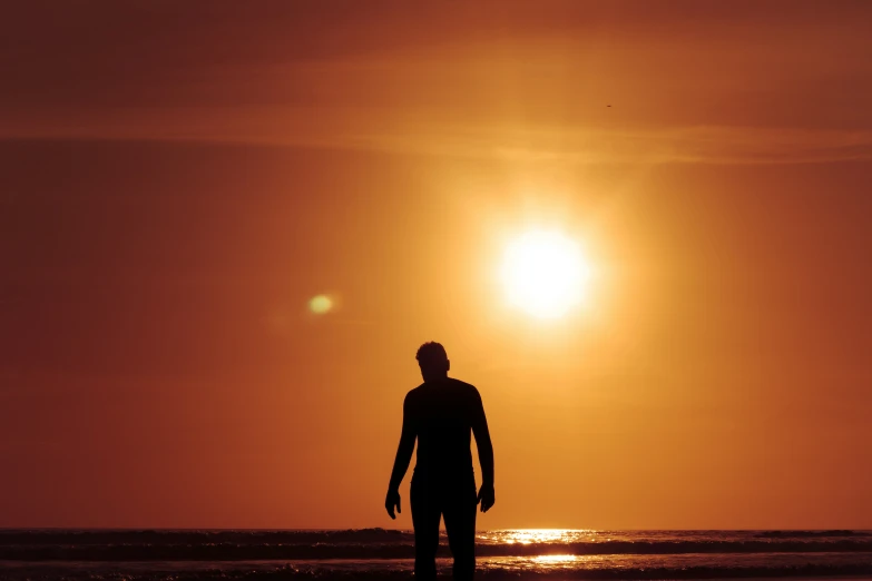 a person on the beach as the sun sets