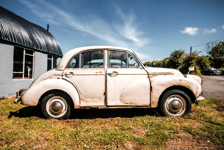 an old car is sitting on the grass