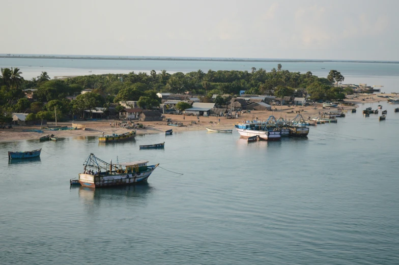 many boats are in the ocean with houses on shore