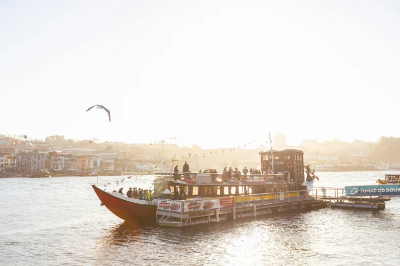 a small boat floating across a lake with a lot of people on it