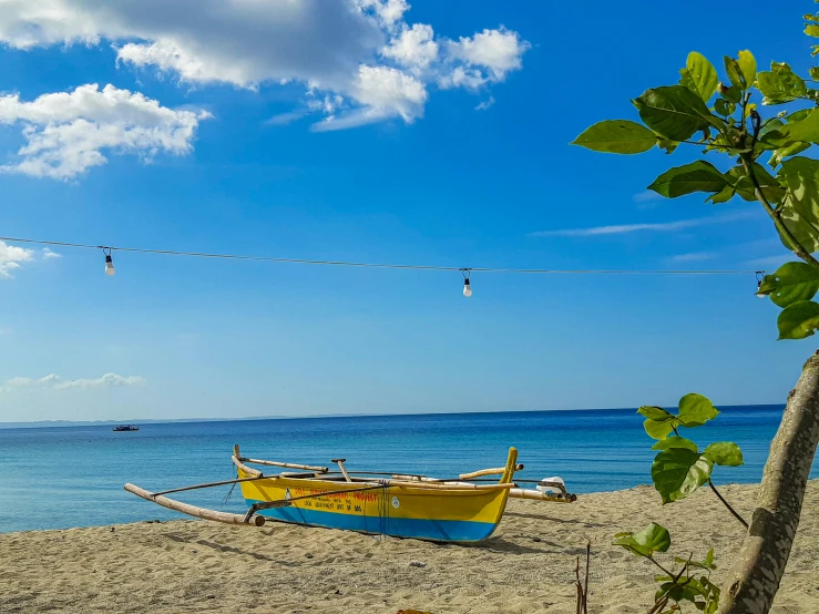 two boats sit on the beach next to the ocean