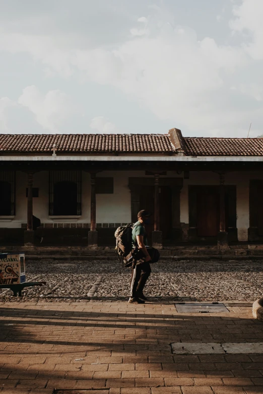 man with backpack walking near an old building