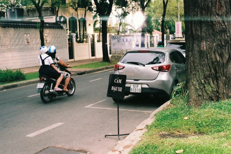 an auto is passing through an intersection next to a tree