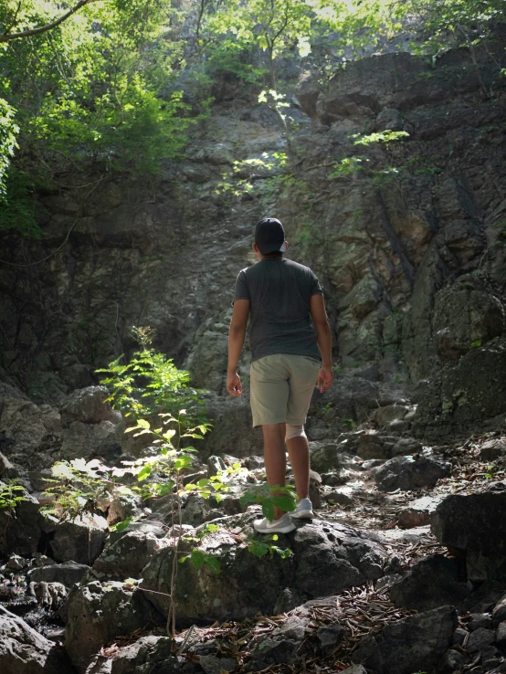 a man walking up a dirt path in the woods