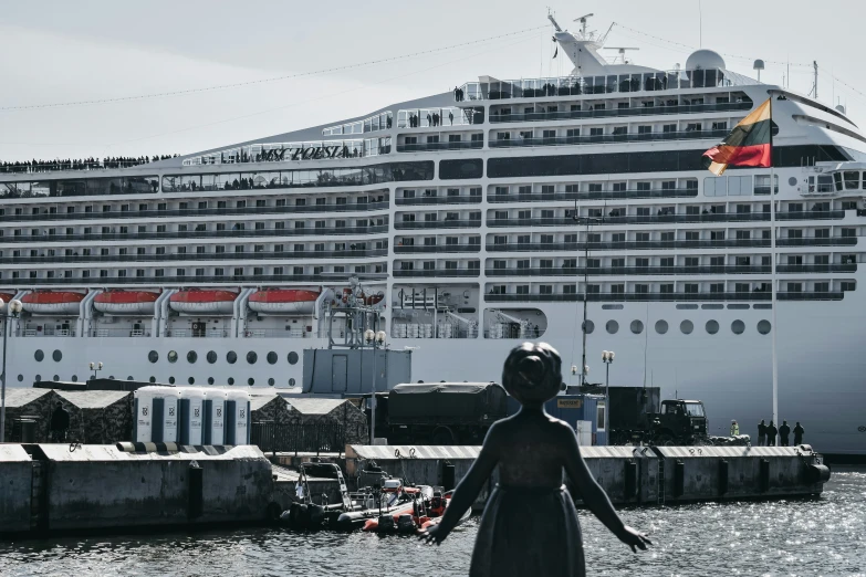 large ship with lots of red chairs in the bay and a statue